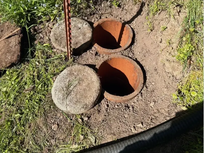 Two septic tank lids opened in a back yard