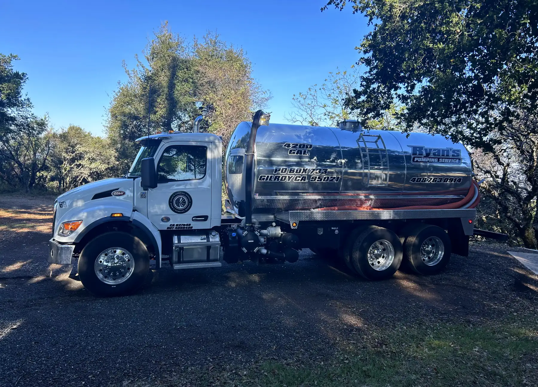 Ryan’s Pumping Service vacuum truck parked under oak trees