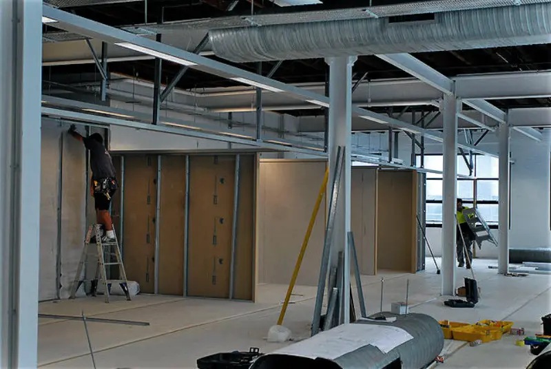 New walls being framed and sheathed under an open ceiling
