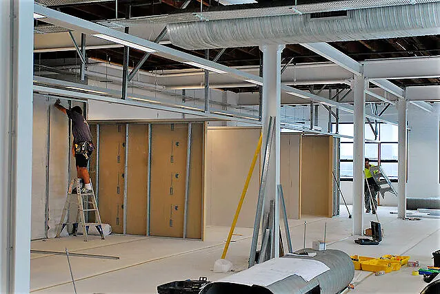 Crew installing drywall and ceiling framing in an office build-out
