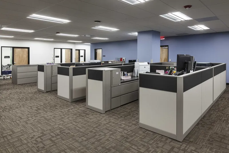 Finished office with workstations under an acoustic ceiling and new lighting