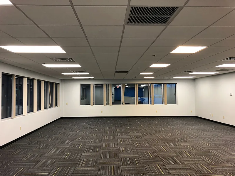 Finished open office floor with acoustic ceiling, lighting and carpet tile, ready for furniture